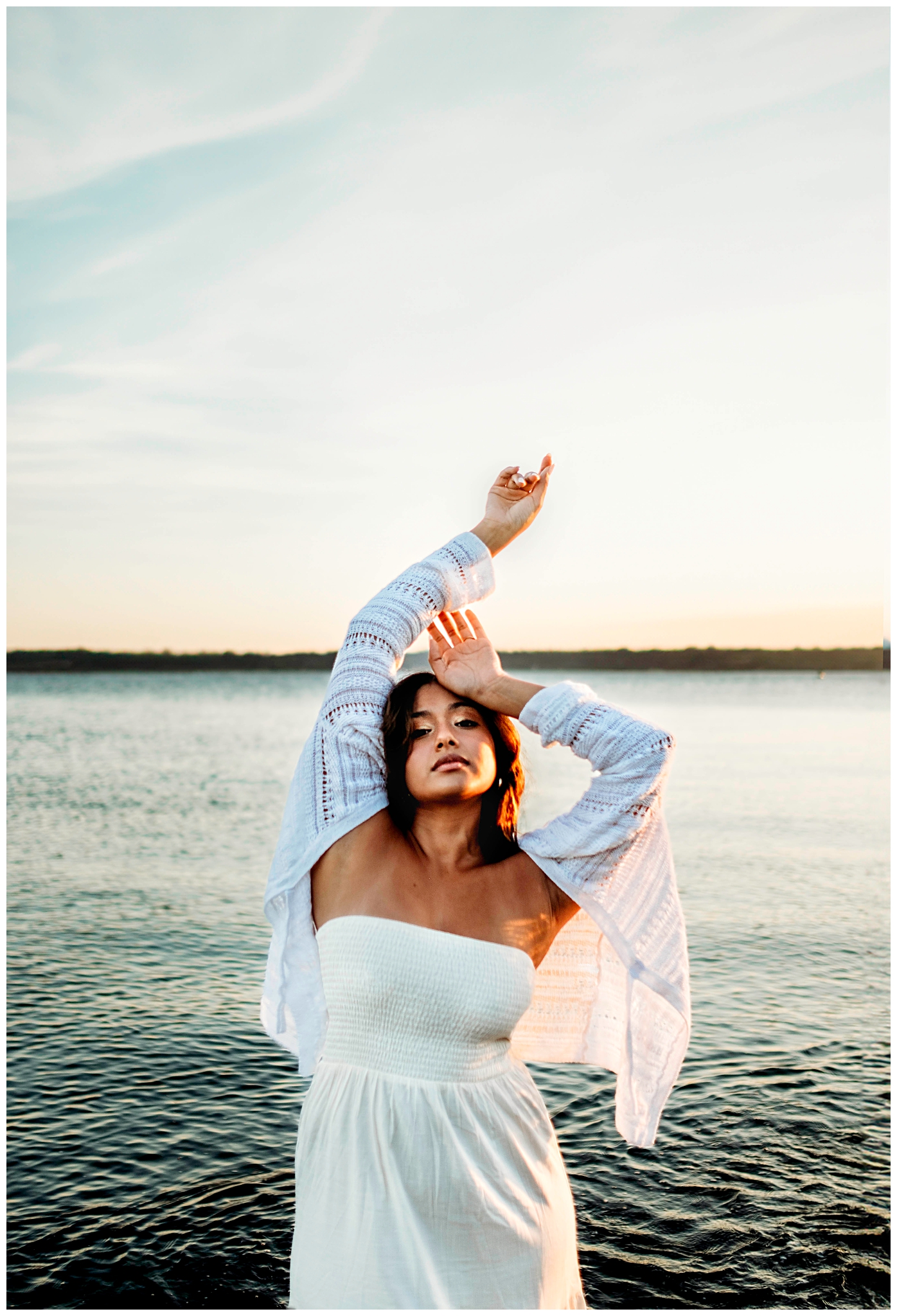 Seattle senior girl leaning on the lighthouse at Discovery Park in Seattle Washington, wearing a white dress, Seattle Summer Senior Portraits