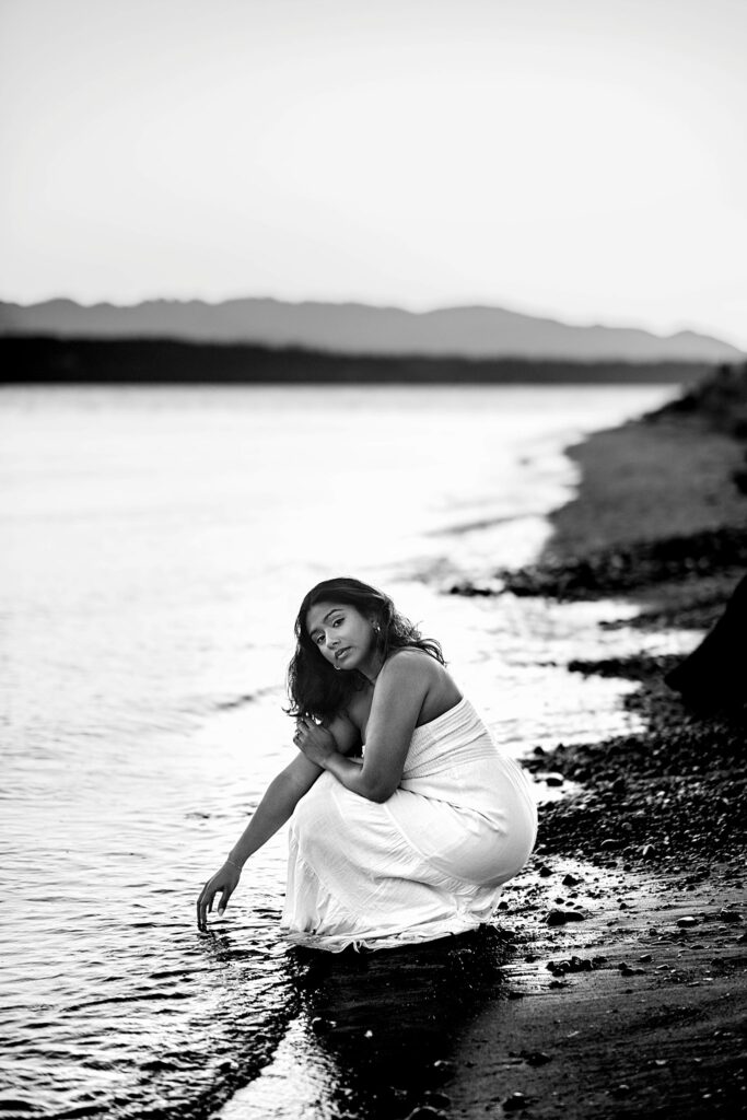 Seattle senior girl leaning on the lighthouse at Discovery Park in Seattle Washington, wearing a white dress, Seattle Summer Senior Portraits